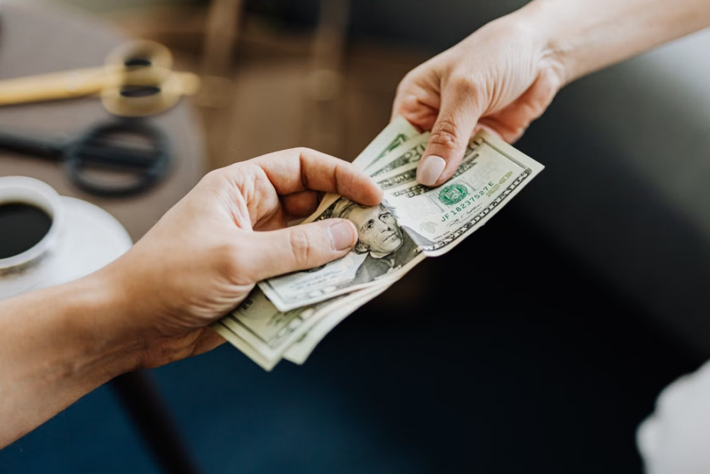 Two people exchanging US dollar bills