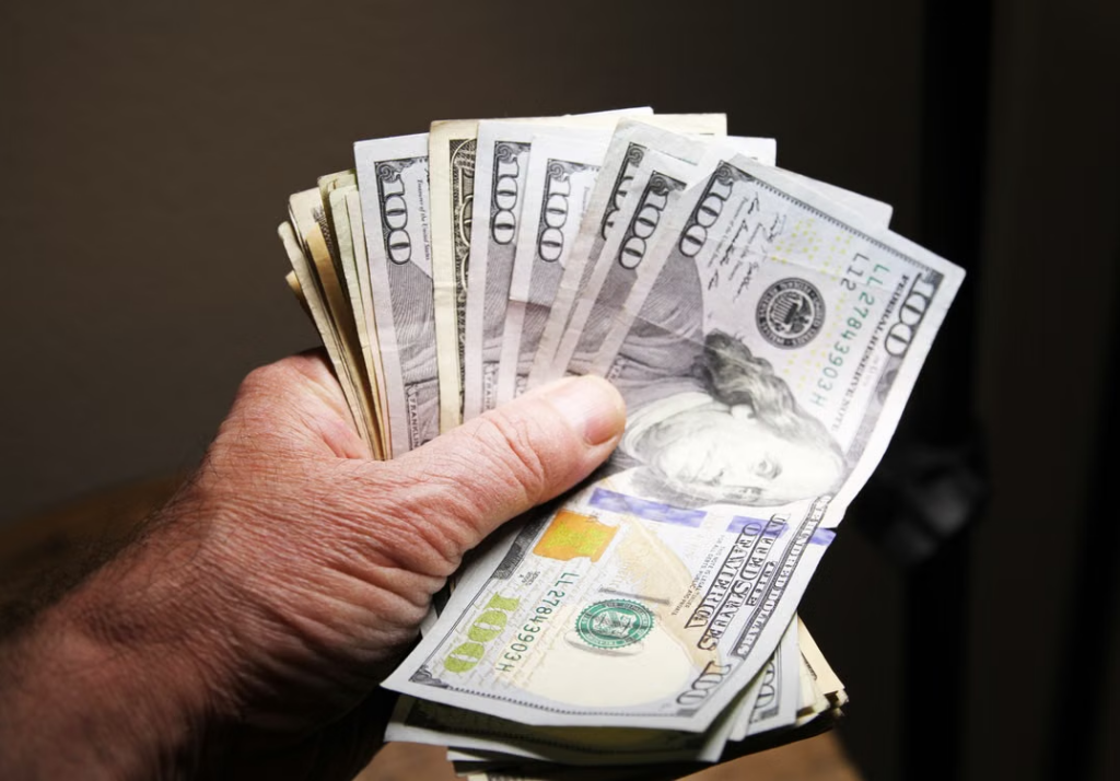 A person holding 100-dollar US bills 